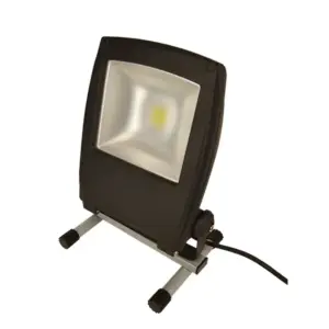 Projektør i sort kabinet med lys, stående på et justerbart stativ, forbundet med en ledning, placeret på en hvid overflade.